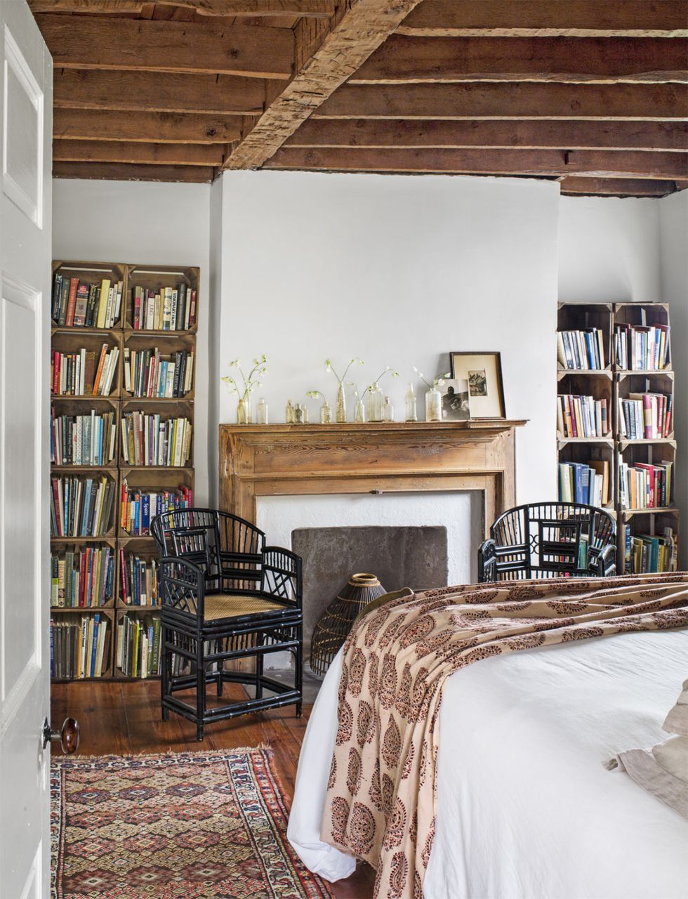 bookshelves made of sweet potato crates in a bedroom with a fireplace in the middle