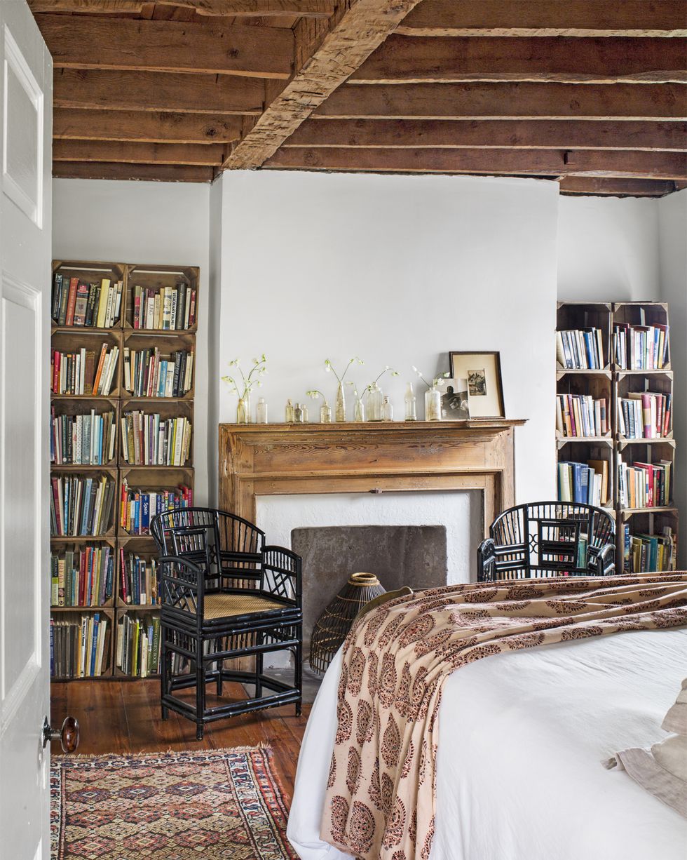 bookshelves made of sweet potato crates in a bedroom with a fireplace in the middle