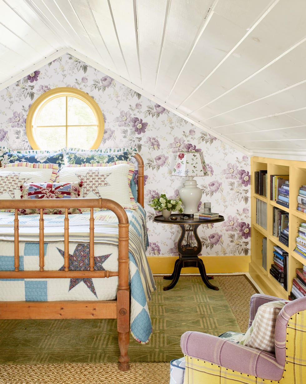 bedroom with purple floral wallpaper, green rug, quilted bedding, and yellow shelves