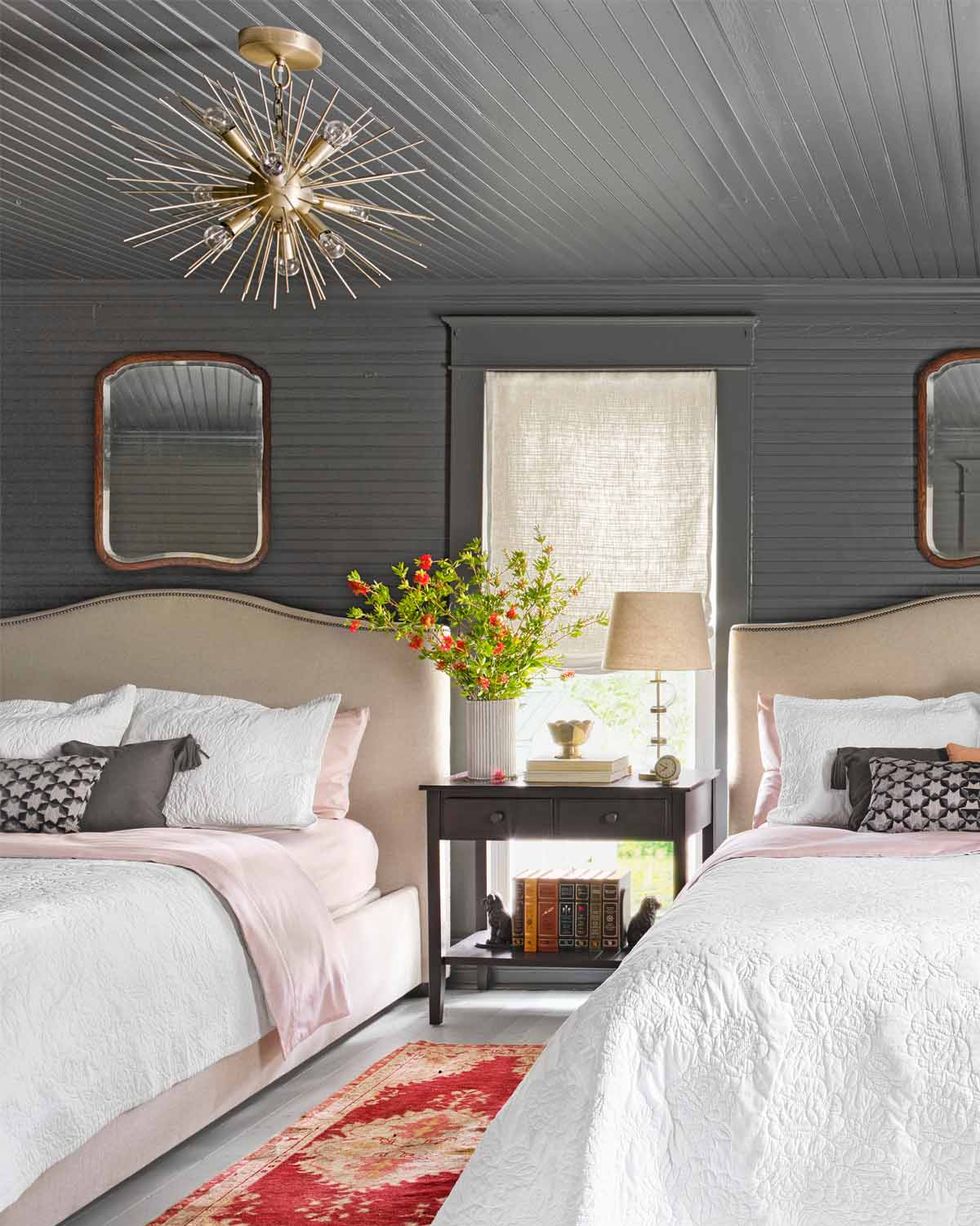 gray bedroom with two upholstered beds and white bedding