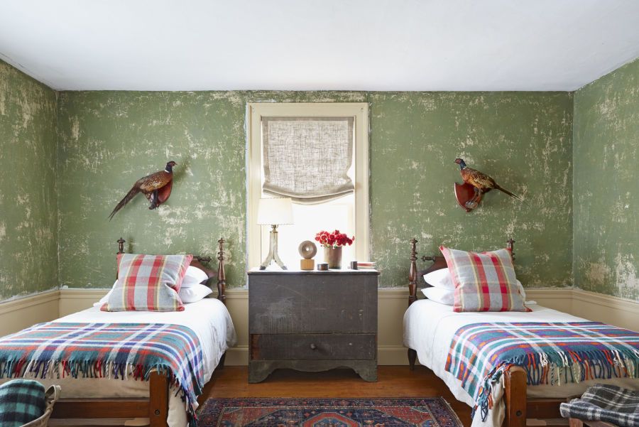 guest room with green worn walls and two twin beds