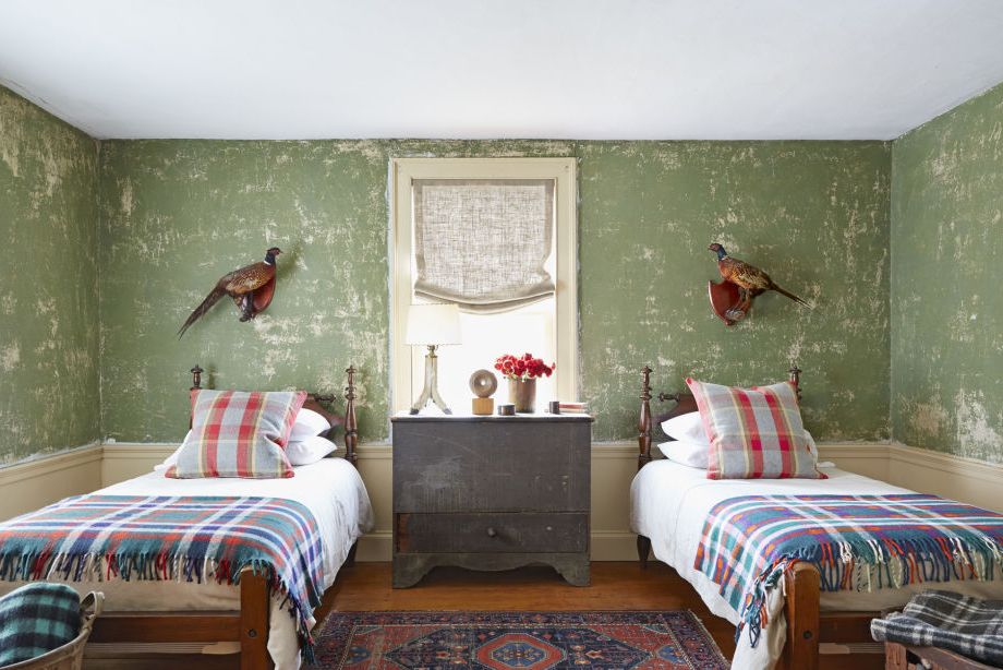 guest room with green worn walls and two twin beds