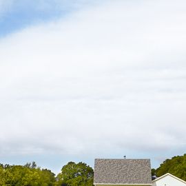 tiny white farmhouse in green landscape