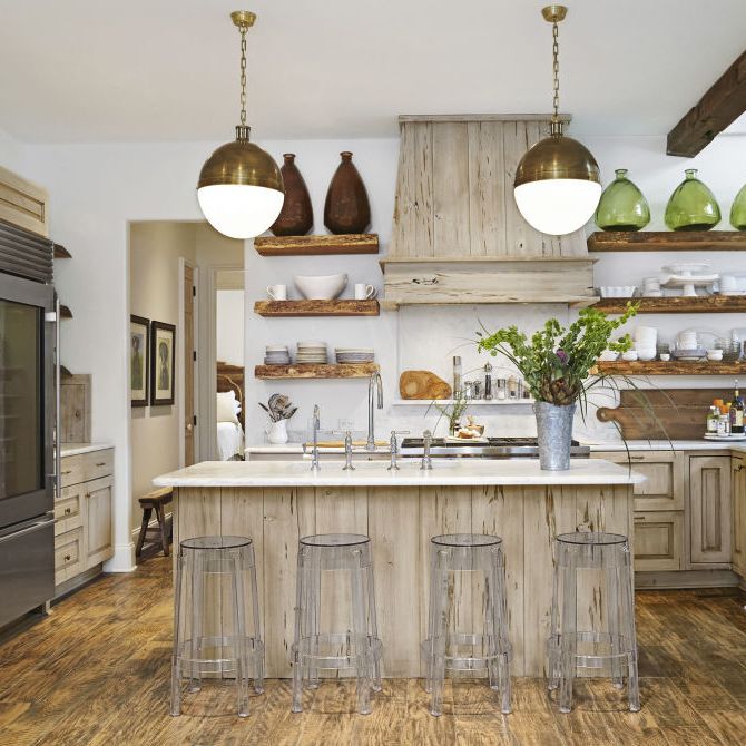 an all wood kitchen with clear barstools and white countertops