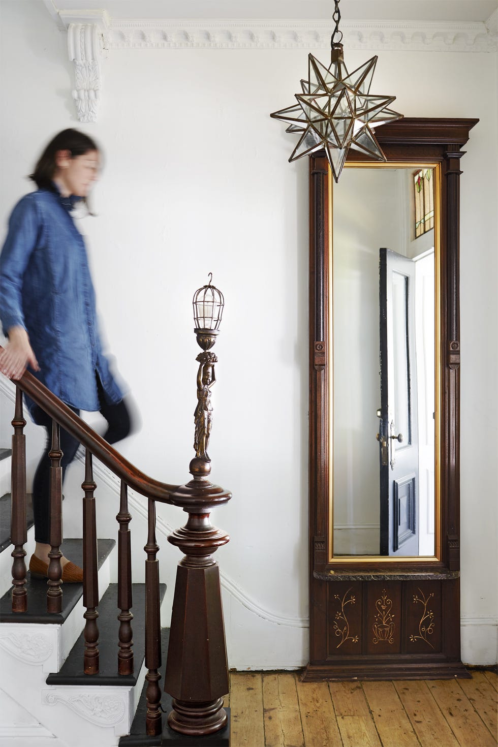 white entryway featuring wooden stairs that have a decorative newel post