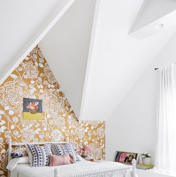 a girls bedroom with an accent wall in bold gold and white floral design