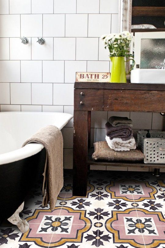 bathroom with pink orange and black patterned tile and a black clawfoot tub