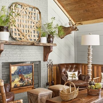 a rustic living room with painted brick and paneling and a fireplace as a focal point