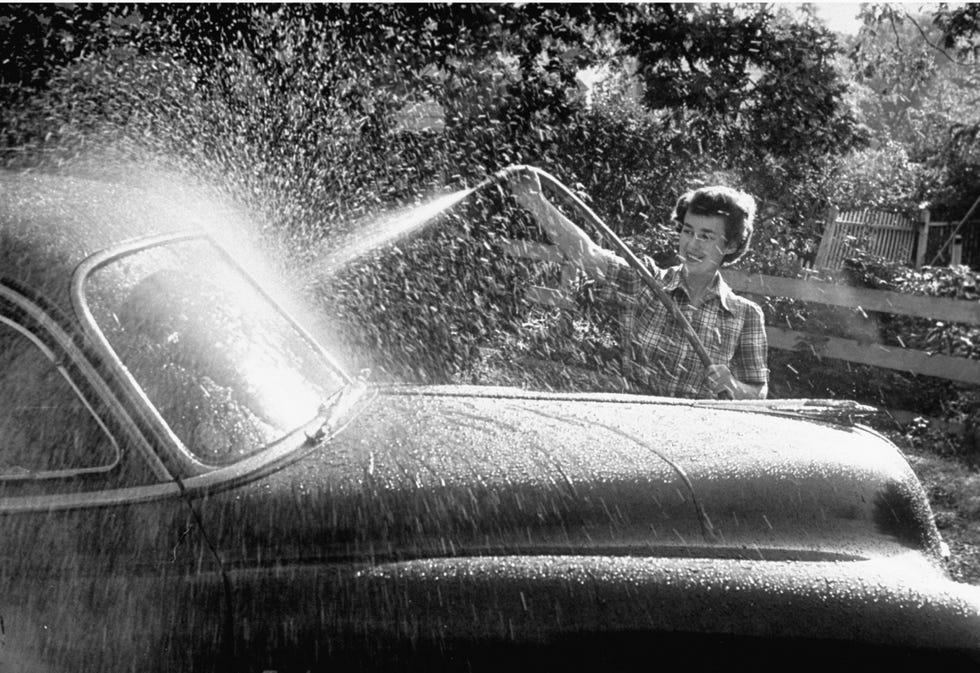 chica lavando un coche en los años 50