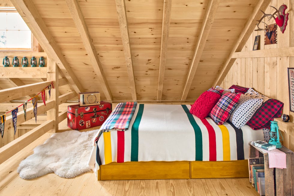 cozy loft bedroom with wood platform bed topped with a striped pendleton blanket