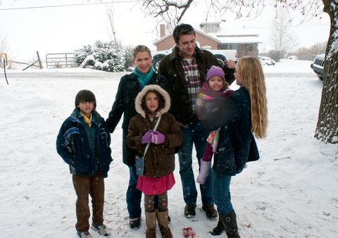 family with children standing in the snow