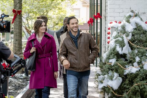 man and woman walking down street at christmas time