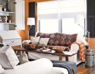 orange family room with white furniture and shelves and patchwork blankets