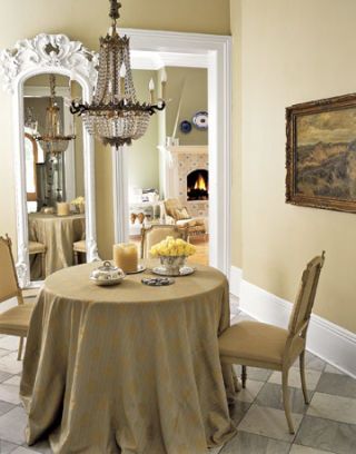 neutral dining room with small table and chandelier