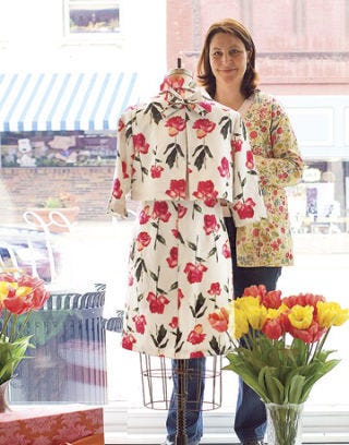Michelle Rose Jorgensen with a Dress in her Shop