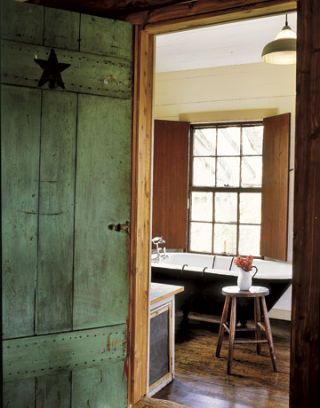 green door with star leading into bathroom with iron tub