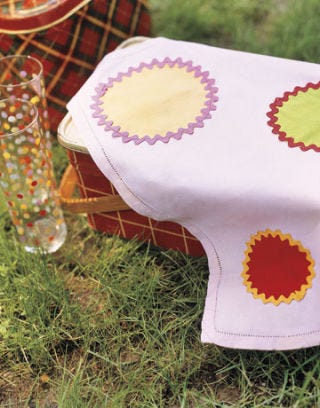 polka dot napkin and glasses on top of plaid picnic pail