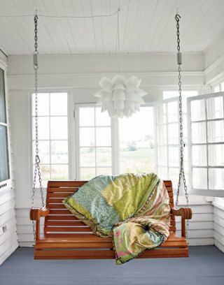 quilt on swinging wooden bench on the porch
