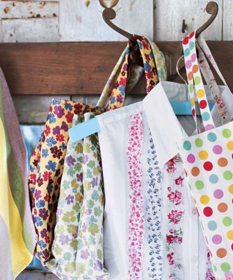 multicolored floral and polka dot tote bags hanging on hooks with white blouse