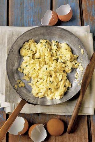 scrambled eggs with chives in a pan