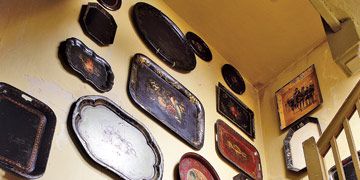tole trays displayed above the stairs