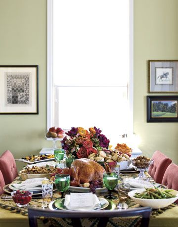 thanksgiving table with a turkey and flowers and side dishes