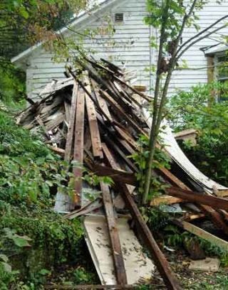 stripped aluminum siding of house in the yard