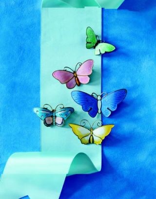 colorful enameled butterfly pins on blue background