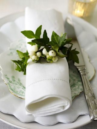 Instead of a traditional napkin ring, tie greenery into circular form.