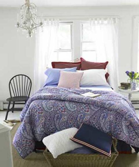 a bed with layered patterns paisley stripes in red white and blue colors