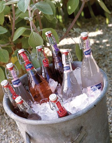 large bottles of lemonade in a bucket of ice outside