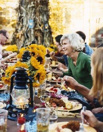 guests eating at an outdoor table with sunflowers and lanterns