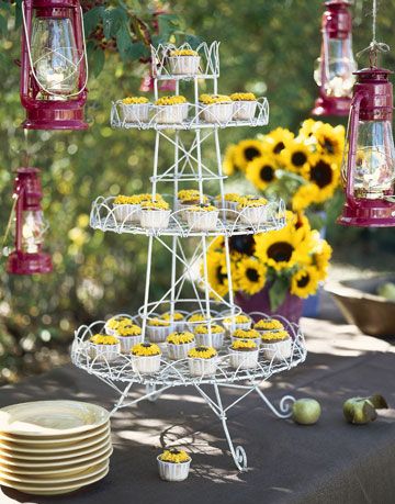 tiered dessert tray with sunflower cupcakes surrounded by suspended lanterns