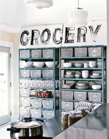 blue metal shelves hold bins dishes water and potatoes with a sign that says grocery above