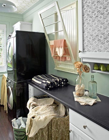 laundry room with foldout drying rack and stacked washer dryer