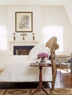 white bedroom with european bed and chair