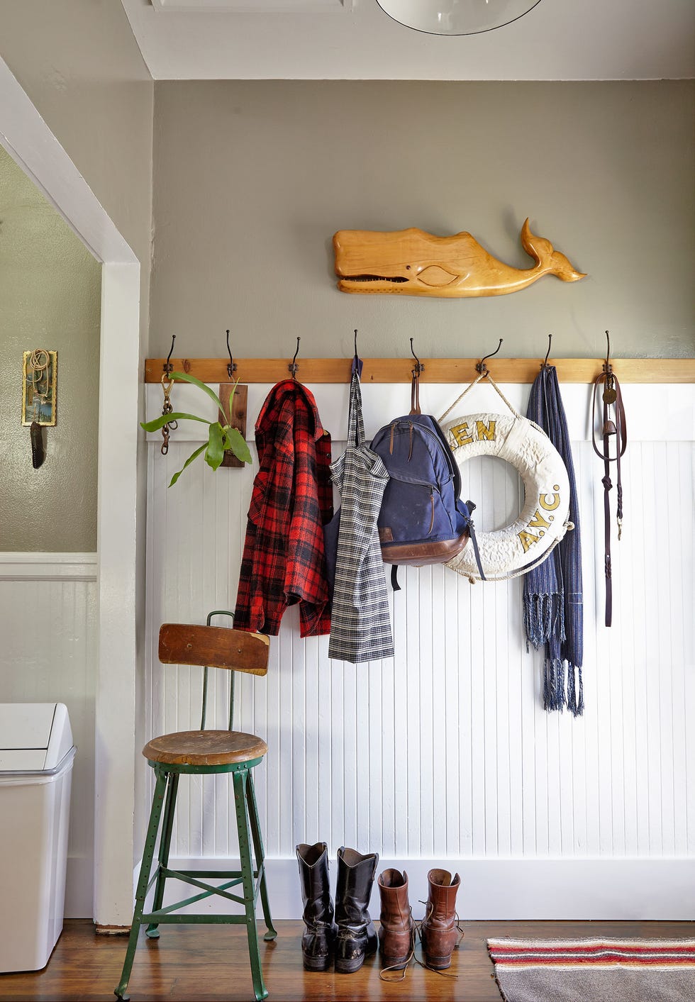mudroom with white beadboard and green wall above