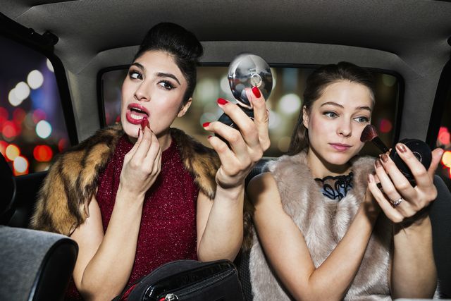 Vrouwen doen make-up in auto