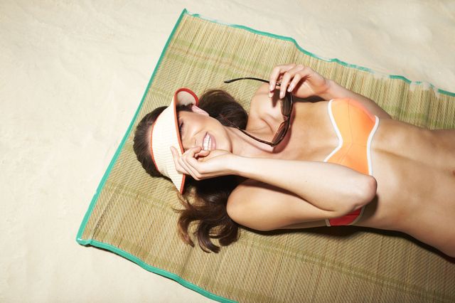 vrouw zon strand bikini zonnebril hoed