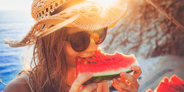 vrouw met hoed watermeloen strand