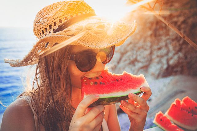 vrouw met hoed watermeloen strand