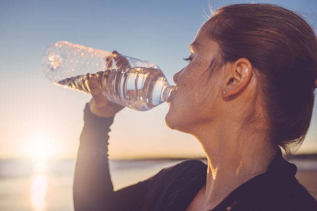 Vrouw drinkt water uit flesje
