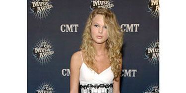 A newcomer on the country music scene, Taylor looks <i>so</i> young in this plain black and white dress and matching T-strap heels.