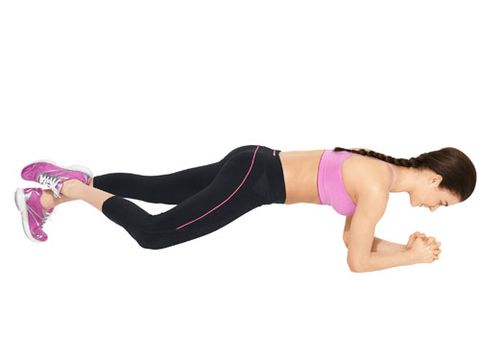 <b>Step 1:</b> Start in a plank: knees off the floor, legs and back straight, belly pulled in. Bend your right leg (knee facing the side, toes pointed), and place your right ankle behind your left.