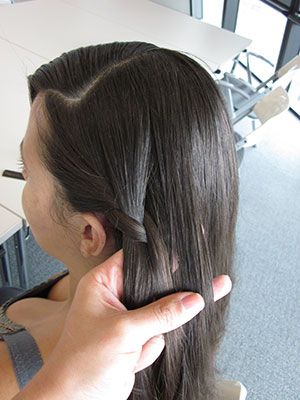 As you continue to braid in a downward slant, grab a new piece of hair and work into the mix each time, similar to the way you'd make a classic French bread. The only difference is that you are braiding half-way around your head, rather than just straight down (see the next photo).  