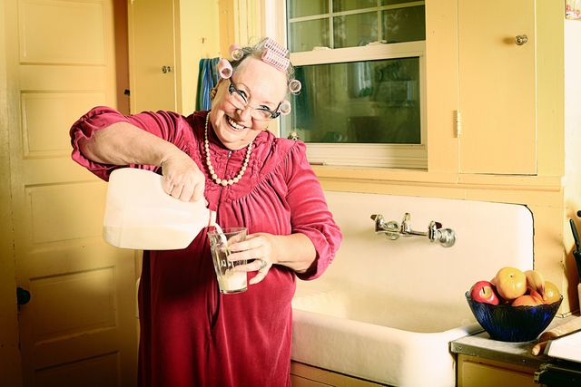Granny with rollers and milk in the kitchen