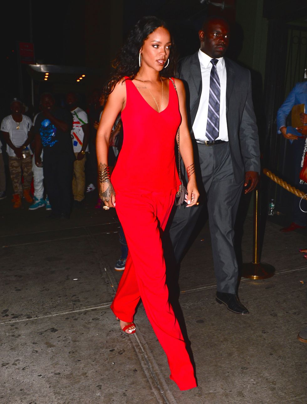 Rihanna wearing a red jumpsuit at a New York Fashion Week party