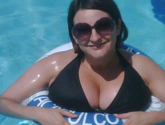 Woman with big boobs swimming with a rubber ring