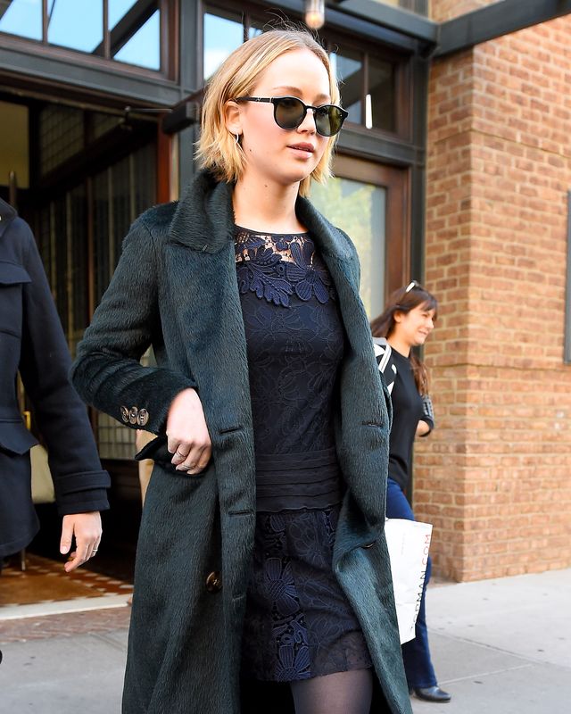 jennifer lawrence walking around new york wearing a black lace outfit topped off with a textured green coat