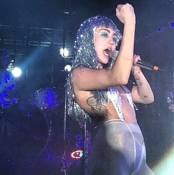 Miley Cyrus wears glittery nipple pasties and a wig made out of tinsel